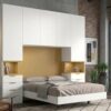 Dormitorio puente de matrimonio con armarios y mesitas en color blanco y madera