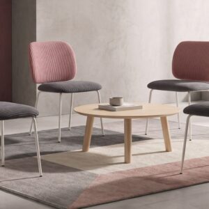 Sillas de comedor Lora con respaldo rosa y asiento gris junto a una mesa de madera