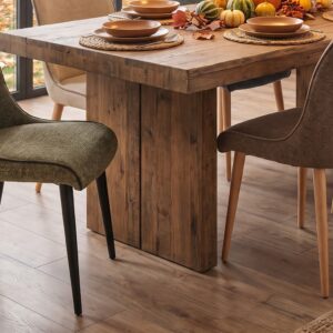 Sillas de comedor Bea tapizadas en verde y tonos beige alrededor de una mesa de madera